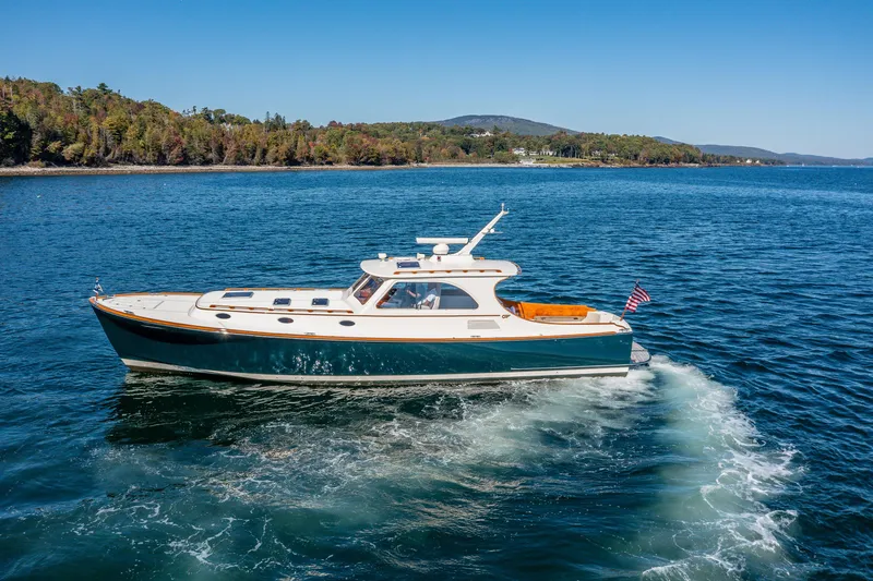 Slide: The Image of 2002 Hinckley Talaria 44 Express yacht cruising on a scenic lake. - 3