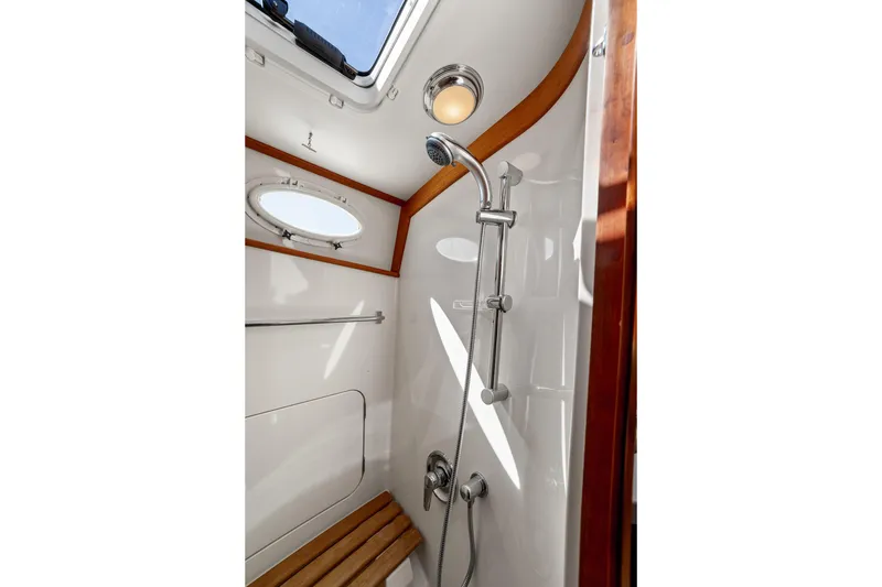 Slide: The Image of Luxurious shower in 2002 Hinckley Talaria 44 Express yacht, featuring wood accents and porthole. - 47