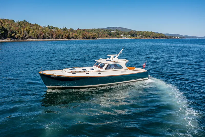 Slide: The Image of 2002 Hinckley Talaria 44 Express yacht cruising on a scenic lake. - 9