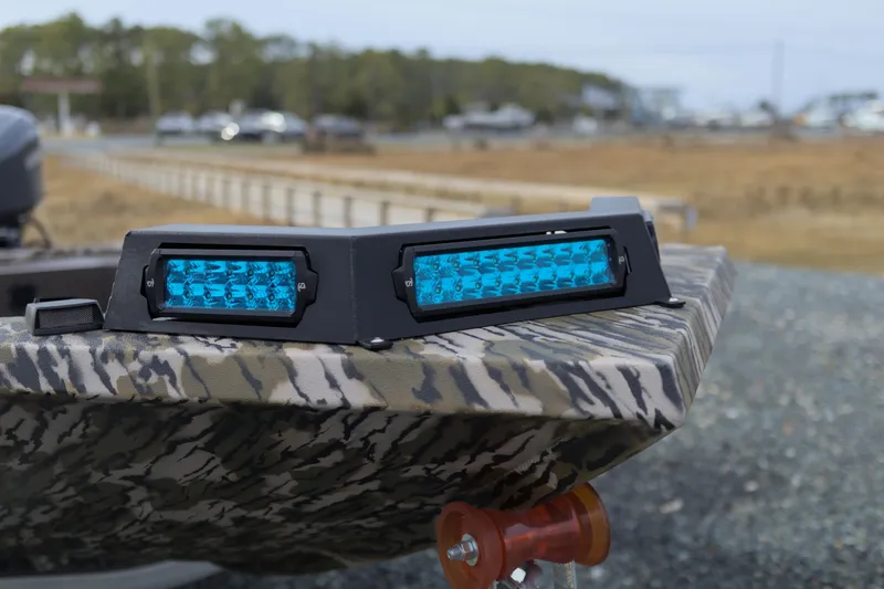 Slide: The Image of 2026 Avid 16 Commander boat with blue LED lights on camouflage-patterned surface. - 9