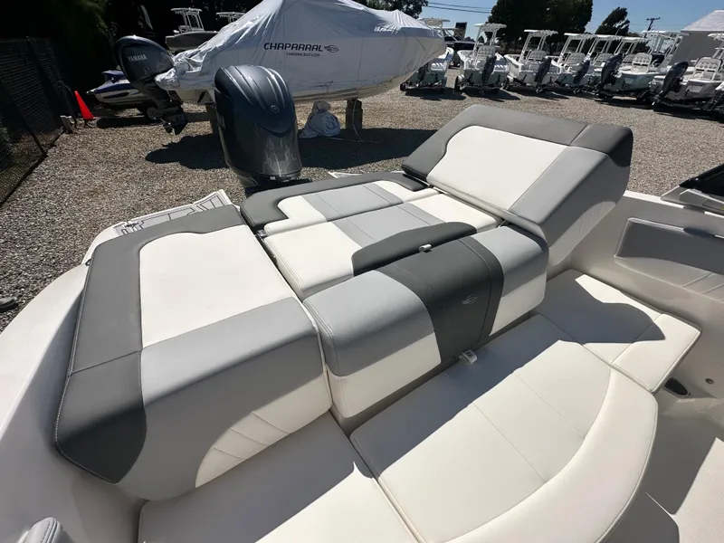 Slide: The Image of 2024 Chaparral 21 SSi OB boat interior with cushioned seating and outboard motor. - 39