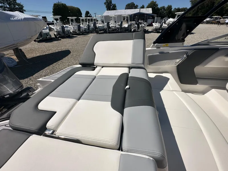 Slide: The Image of 2024 Chaparral 21 SSi OB boat with spacious, cushioned seating in a marina. - 40