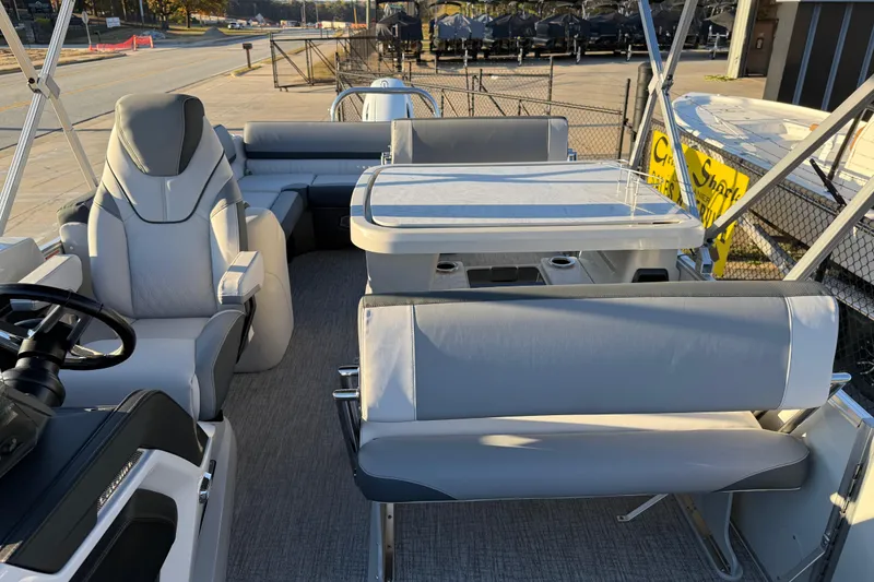 Slide: The Image of 2026 Avalon Catalina Entertainer boat interior with seating and table, docked outdoors. - 19
