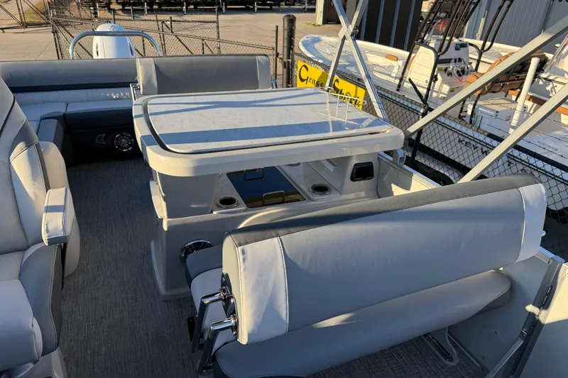 Slide: The Image of 2026 Avalon Catalina Entertainer boat interior with seating and table, docked outdoors. - 20