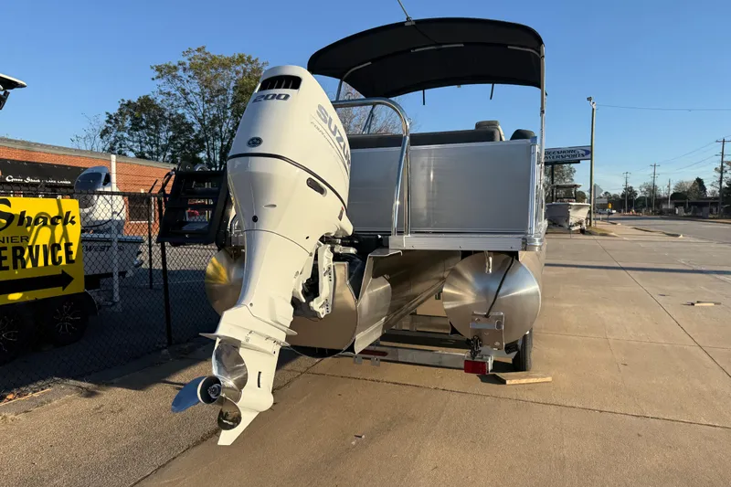 Slide: The Image of 2026 Avalon Catalina Entertainer pontoon boat with Suzuki outboard motor, parked outdoors. - 6