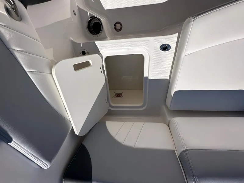Slide: The Image of 2024 Chaparral 21 SSi OB boat interior storage compartment with open door. - 32