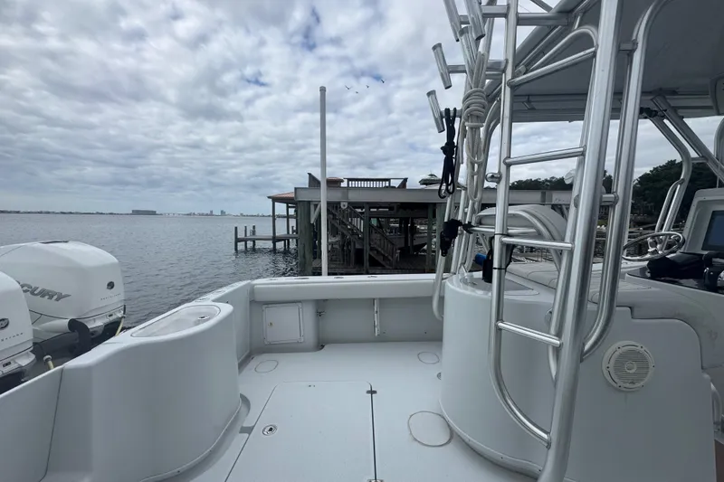 Slide: The Image of 2004 Yellowfin 36 Offshore boat with Mercury engines, docked by a wooden pier under cloudy skies. - 21