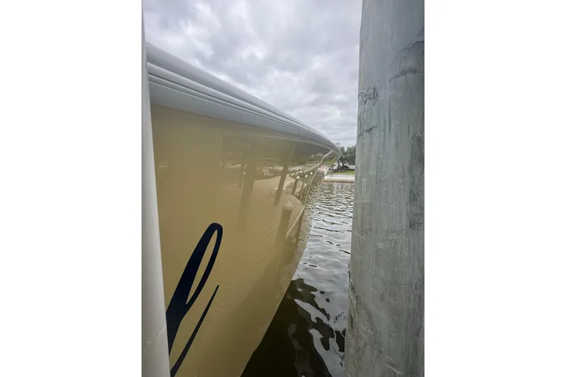 Slide: The Image of Side view of a 2004 Yellowfin 36 Offshore boat docked by a pier. - 26