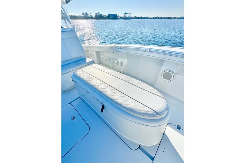 Slide: The Image of 2004 Yellowfin 36 Offshore boat interior with cushioned seating, on calm water. - 28