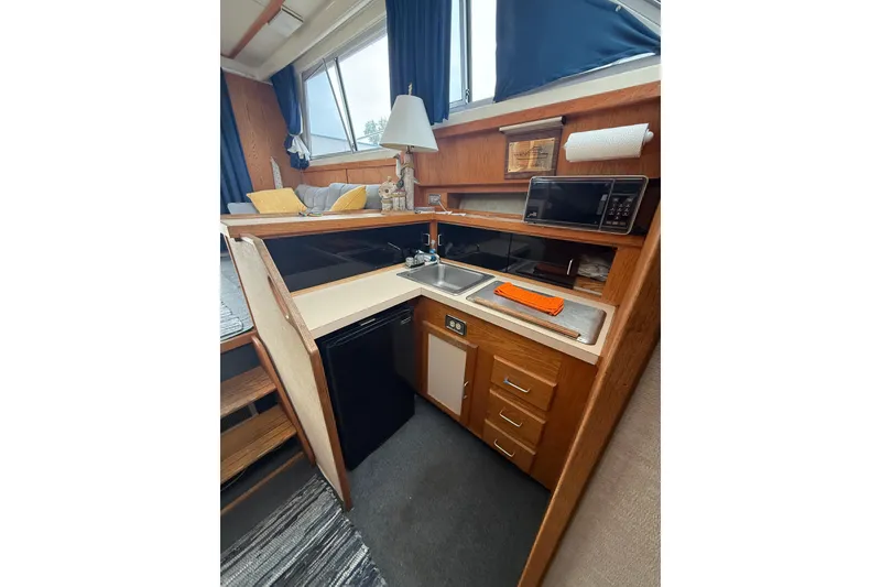 Slide: The Image of 1986 Silverton 34 Convertible interior kitchen with sink, microwave, and wooden cabinetry. - 19