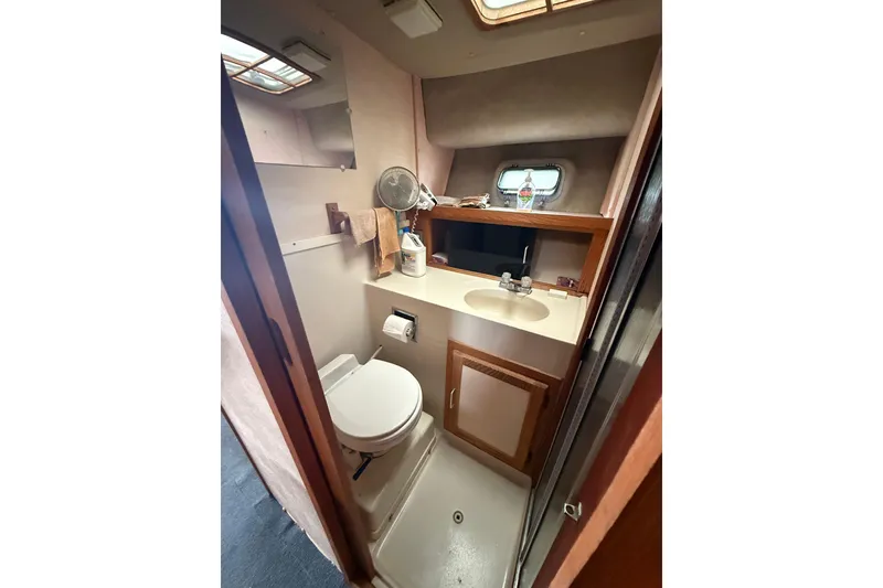 Slide: The Image of Compact bathroom in 1986 Silverton 34 Convertible yacht, featuring sink, toilet, and storage. - 20