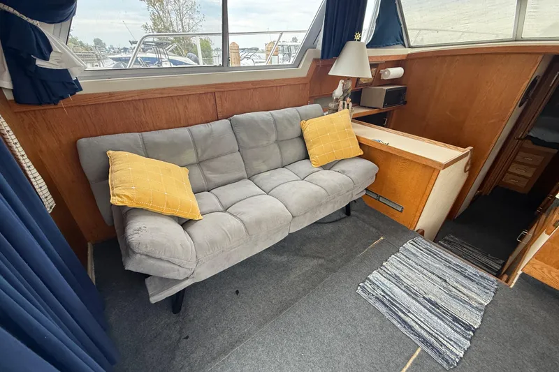 Slide: The Image of Interior of 1986 Silverton 34 Convertible with gray sofa and yellow pillows. - 22