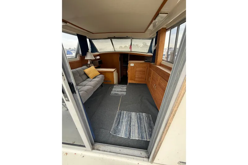 Slide: The Image of Interior of 1986 Silverton 34 Convertible boat with cozy seating and wooden cabinetry. - 23