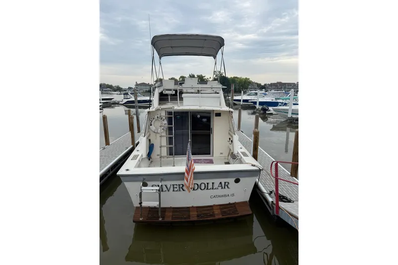 Slide: The Image of 1986 Silverton 34 Convertible boat docked, rear view with American flag. - 3