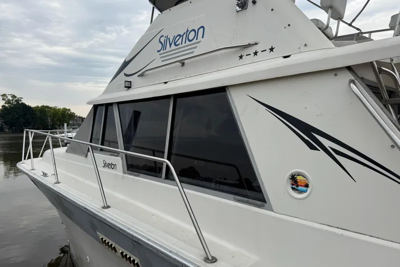 Slide: The Image of 1986 Silverton 34 Convertible boat docked, featuring sleek design and logo details. - 4