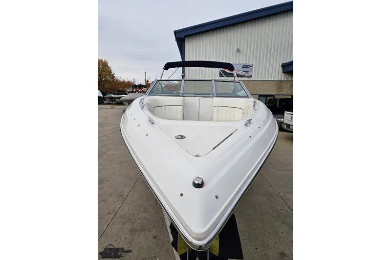 Slide: The Image of 2007 Cobalt 252 boat with white exterior, docked near a building. - 15