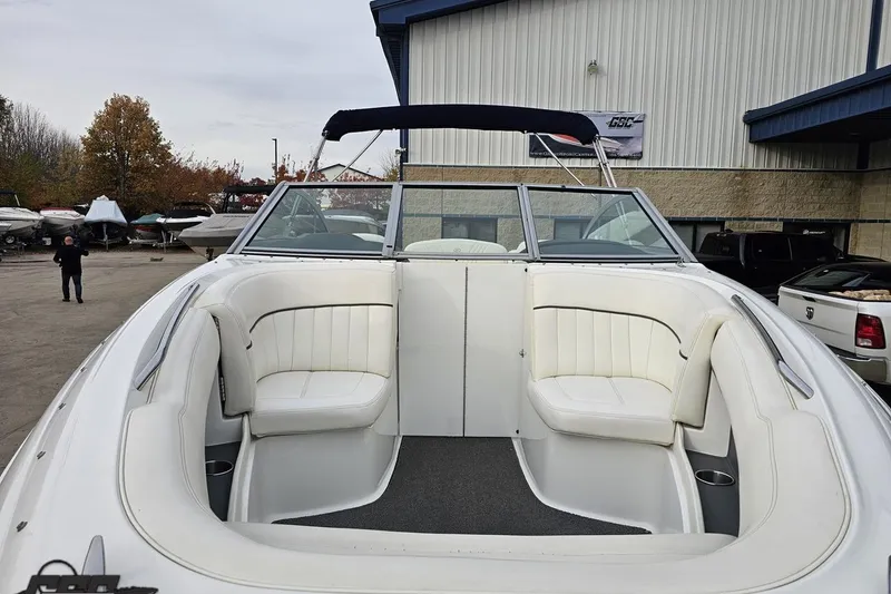 Slide: The Image of 2007 Cobalt 252 boat with white seating, parked outdoors near a warehouse. - 16