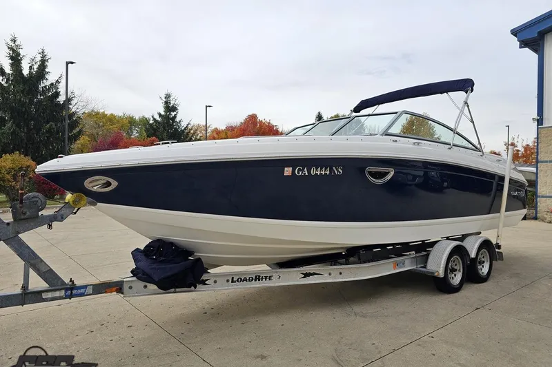 Slide: The Image of 2007 Cobalt 252 boat on trailer, parked outdoors with autumn trees in background. - 18