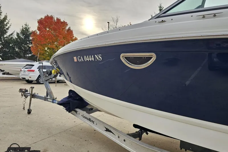 Slide: The Image of 2007 Cobalt 252 boat on trailer, autumn trees in background, overcast sky. - 22