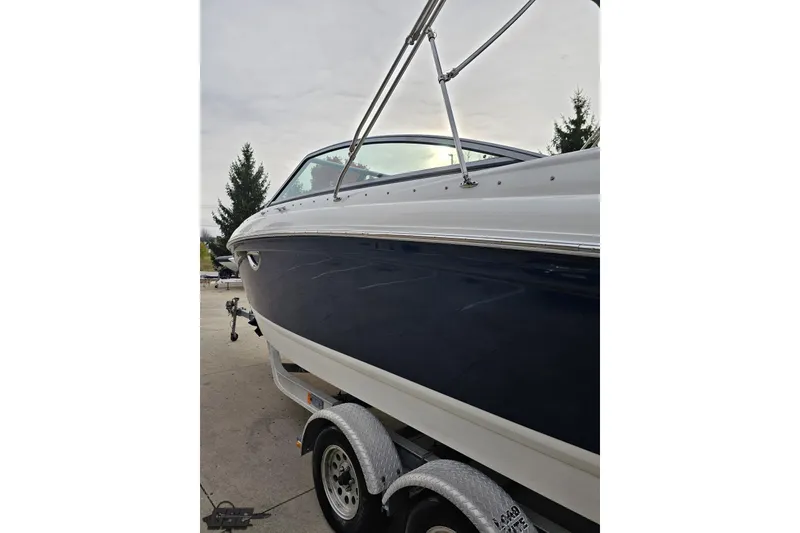 Slide: The Image of 2007 Cobalt 252 boat on trailer, side view with sleek design and blue hull. - 24