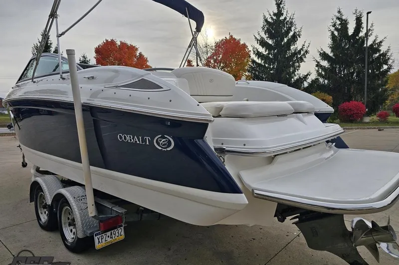Slide: The Image of 2007 Cobalt 252 boat on trailer, parked outdoors with autumn trees in background. - 28