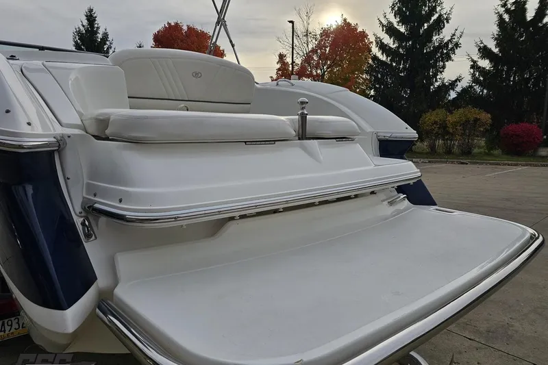 Slide: The Image of 2007 Cobalt 252 boat rear view with swim platform and seating, autumn trees in background. - 30