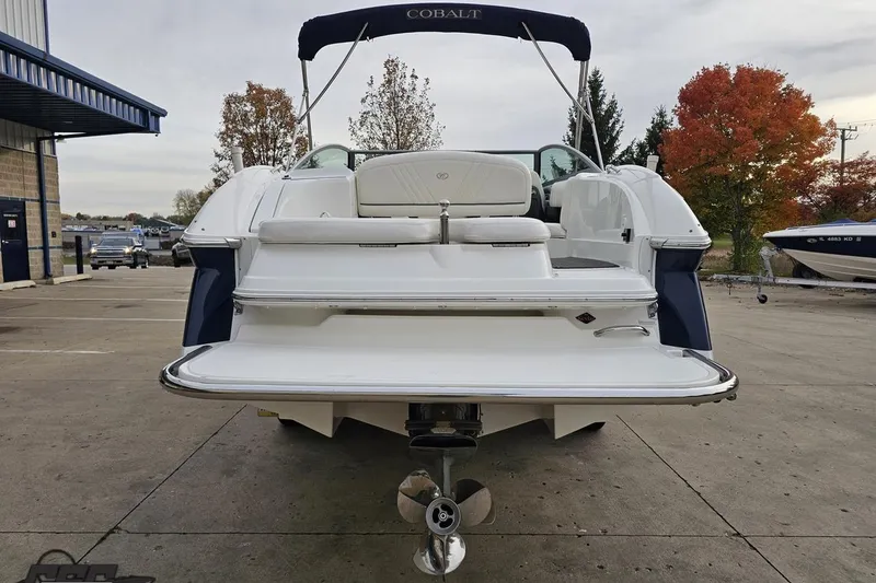 Slide: The Image of 2007 Cobalt 252 boat with swim platform, docked outdoors, autumn trees in background. - 32
