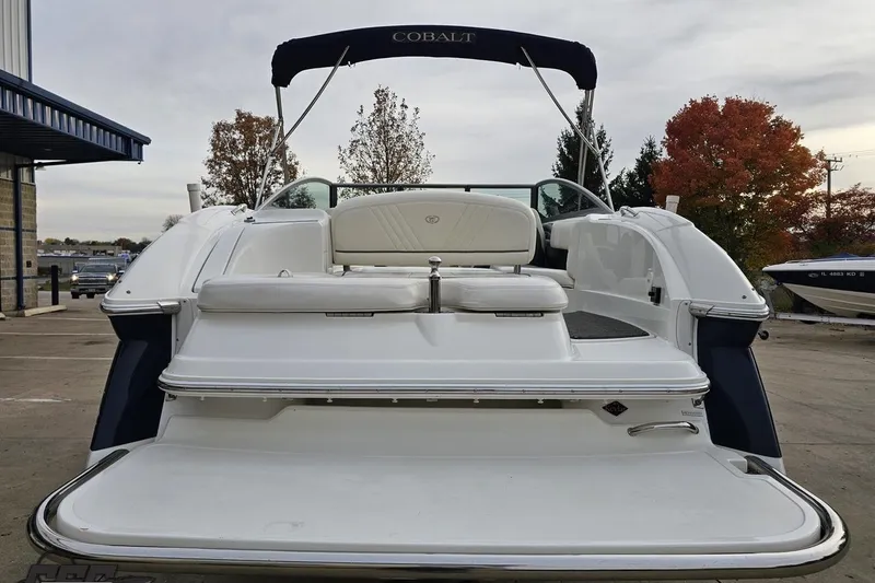 Slide: The Image of 2007 Cobalt 252 boat with white seating and swim platform, parked outdoors. - 39