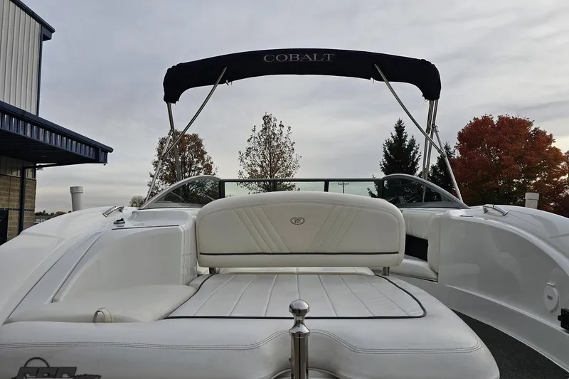 Slide: The Image of 2007 Cobalt 252 boat with white seating and canopy, parked outdoors. - 41