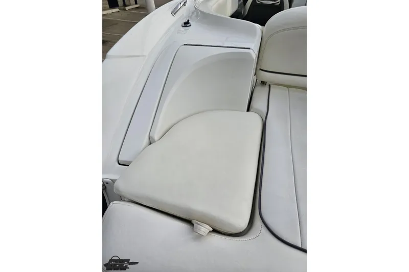 Slide: The Image of 2007 Cobalt 252 boat interior with white cushioned seating and storage compartment. - 45
