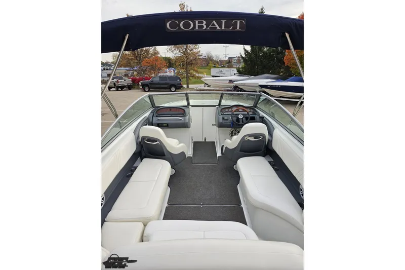 Slide: The Image of 2007 Cobalt 252 boat interior with white seating and steering wheel, parked outdoors. - 53