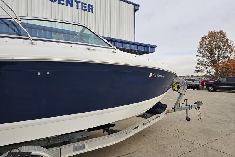 Slide: The Image of 2007 Cobalt 252 boat on trailer outside a building, autumn trees in background. - 6
