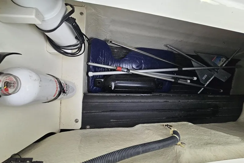Slide: The Image of Storage compartment in a 2007 Cobalt 252 boat with fire extinguisher and equipment. - 64