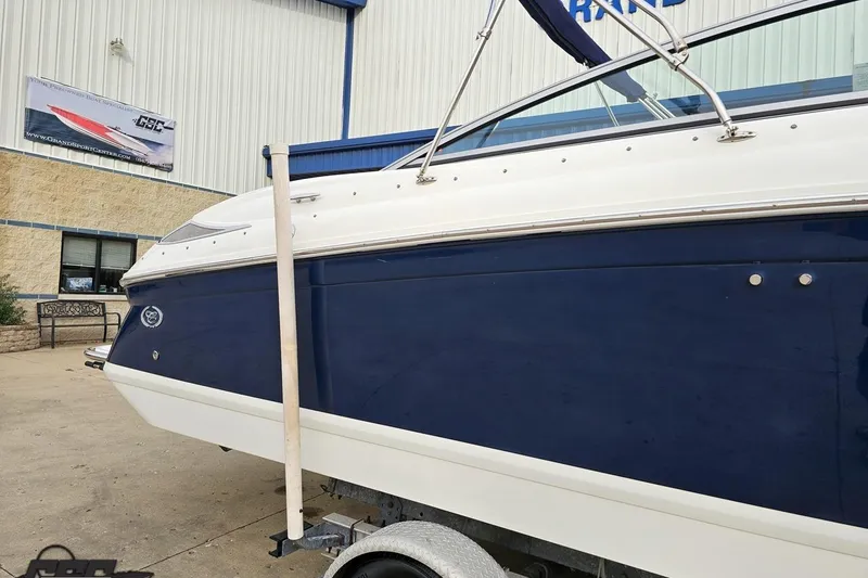 Slide: The Image of 2007 Cobalt 252 boat with blue and white exterior, parked outside a building. - 7