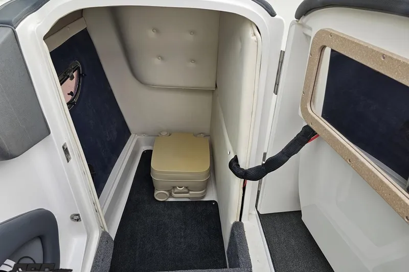 Slide: The Image of 2007 Cobalt 252 boat interior with compact toilet and carpeted flooring. - 74