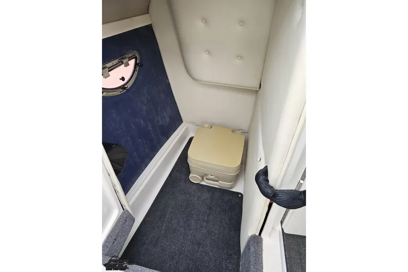 Slide: The Image of 2007 Cobalt 252 boat interior with portable toilet and carpeted flooring. - 75