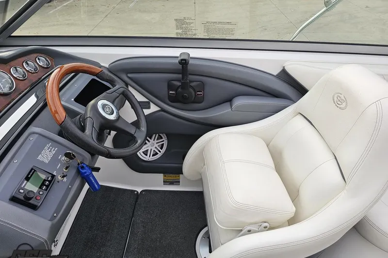 Slide: The Image of 2007 Cobalt 252 boat interior with steering wheel and white captain's chair. - 78