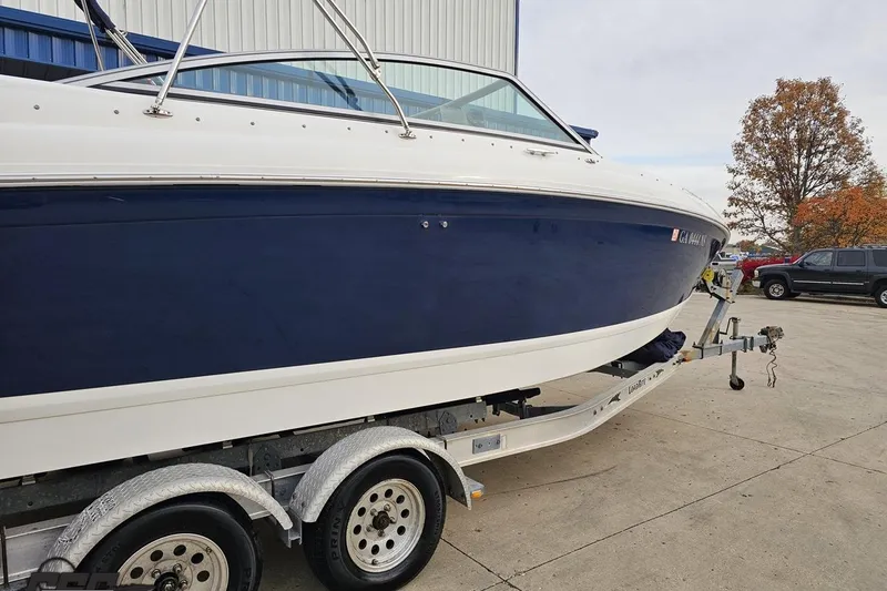 Slide: The Image of 2007 Cobalt 252 boat on trailer, blue and white exterior, parked outdoors. - 8