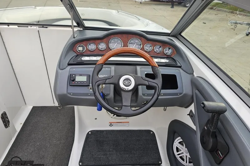 Slide: The Image of 2007 Cobalt 252 boat dashboard with wood-accented steering wheel and instrument panel. - 81