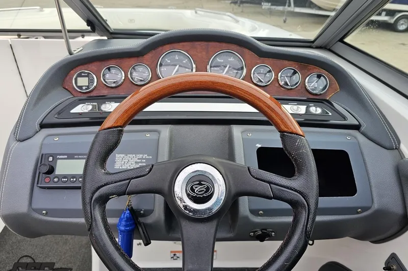 Slide: The Image of 2007 Cobalt 252 boat dashboard with wood-accented steering wheel and instrument panel. - 83