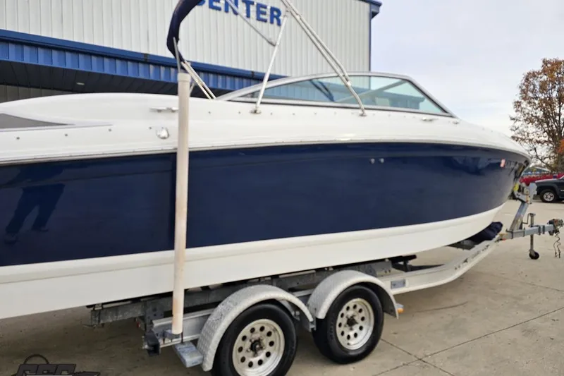 Slide: The Image of 2007 Cobalt 252 boat on trailer, blue and white exterior, parked outside a building. - 9
