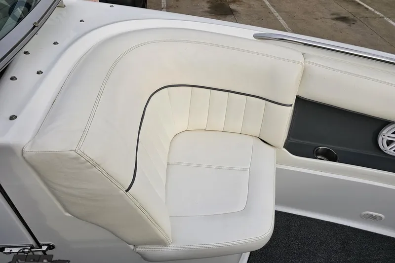 Slide: The Image of White leather seating on a 2007 Cobalt 252 boat, featuring cup holder and speaker. - 96