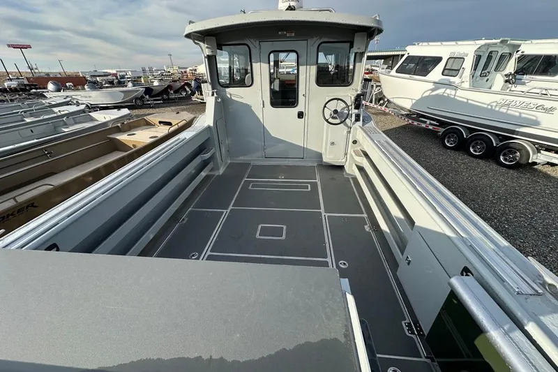 Slide: The Image of 2025 Hewescraft 270 Pacific Explorer boat interior, showcasing spacious deck and steering area. - 4