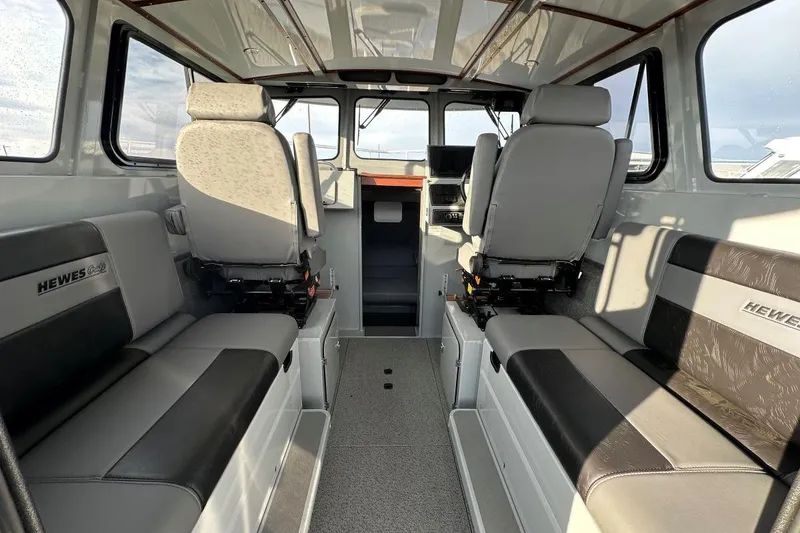 Slide: The Image of Interior of 2025 Hewescraft 270 Pacific Explorer boat, featuring seating and helm area. - 5