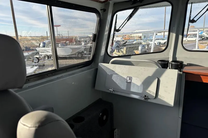 Slide: The Image of Interior view of 2025 Hewescraft 270 Pacific Explorer boat, showcasing seating and windows. - 7