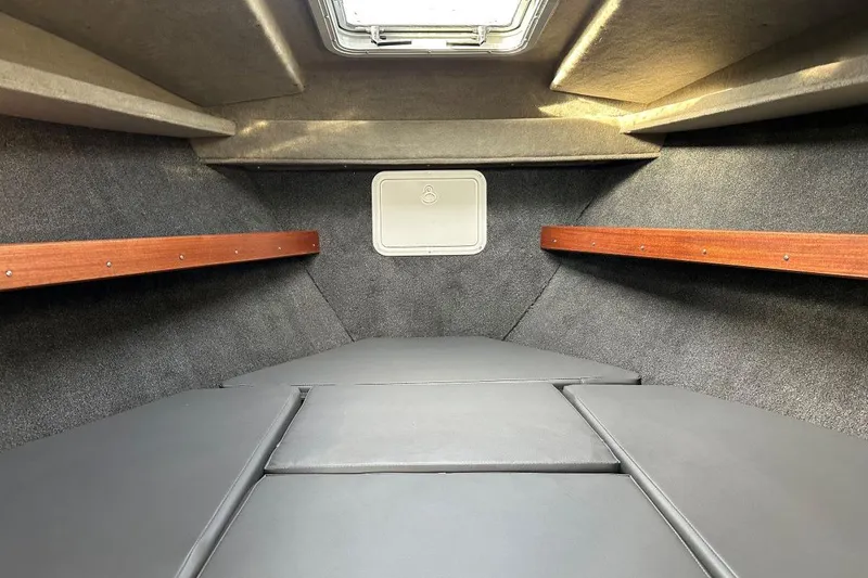 Slide: The Image of Interior cabin of 2025 Hewescraft 270 Pacific Explorer, featuring cushioned seating and wooden accents. - 8