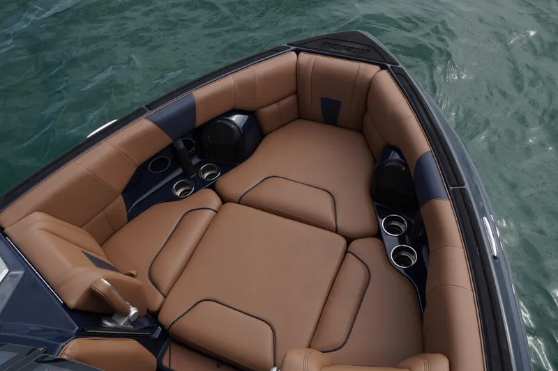 Slide: The Image of 2023 Malibu Wakesetter 23 LSV boat interior with brown leather seating and cup holders. - 12