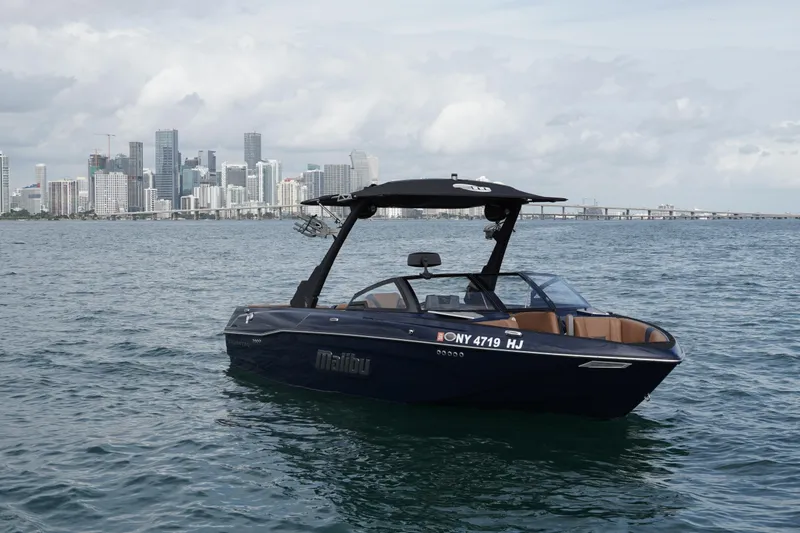 Slide: The Image of 2023 Malibu Wakesetter 23 LSV boat on water with city skyline background. - 17