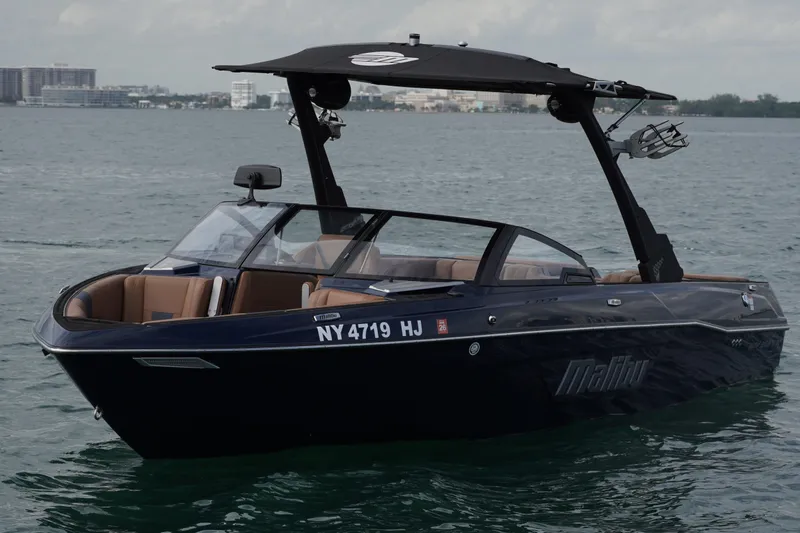 Slide: The Image of 2023 Malibu Wakesetter 23 LSV boat on water, sleek design, black exterior. - 22