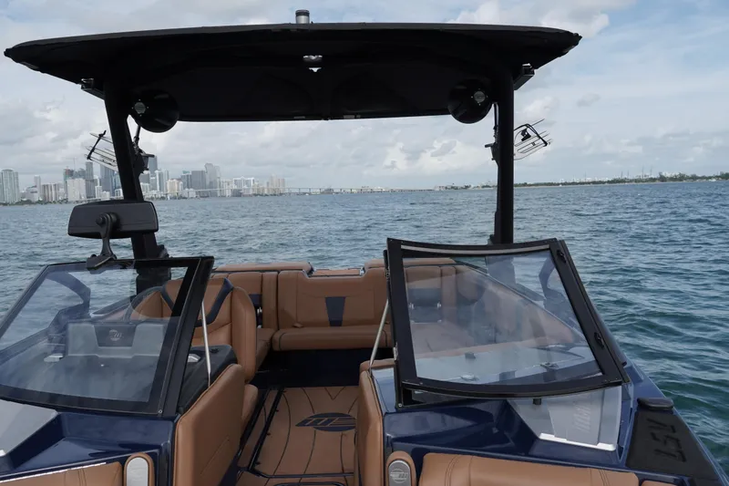 Slide: The Image of 2023 Malibu Wakesetter 23 LSV boat on water with city skyline in background. - 8